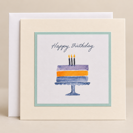 15 x 15 cm cream birthday card featuring a pastel watercolour cake illustration and Happy Birthday lettering, with a white envelope