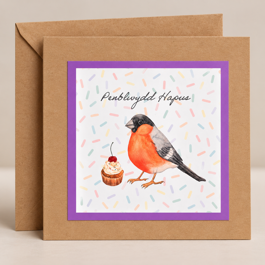 15 x 15 cm natural Kraft Welsh birthday card featuring a watercolour bullfinch and cupcake with pastel confetti, purple border and Penblwydd Hapus lettering