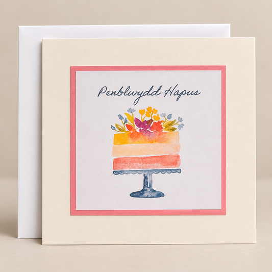 15 x 15 cm off-white Welsh birthday card featuring a colourful watercolour cake decorated with flowers and the words Penblwydd Hapus, with a white envelope